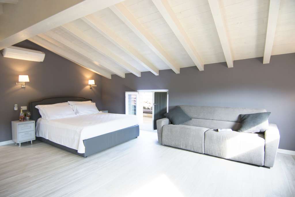 letto e divano sotto il romantico tetto bianco