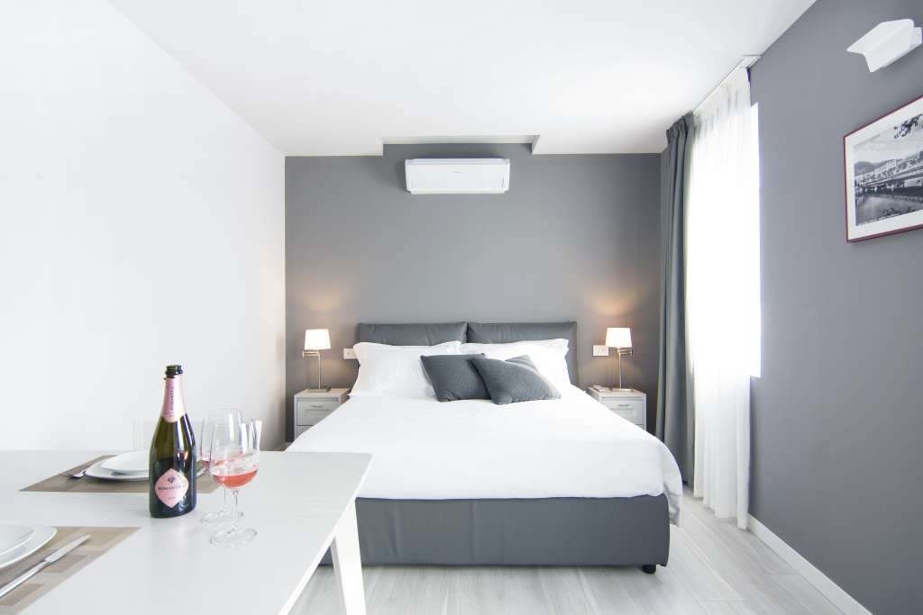 a double bed, a bottle of sparkling rose wine and a window over the city center